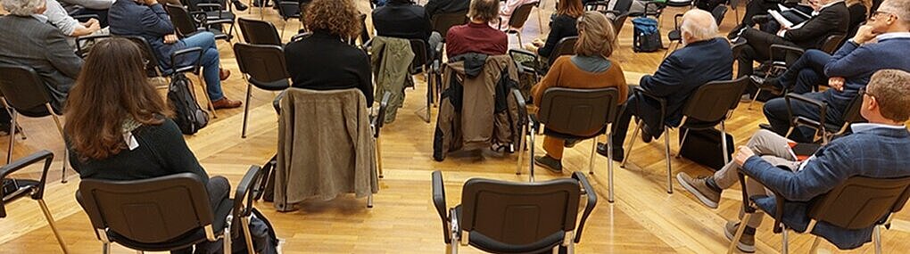 Diskussion bei der Veranstaltung Plattform Grüne Chemie - Zukunft:Chemie Es werden Sesselkreise gezeigt mit einer Diskussionsrunde von 5 Personen in der Mitte.